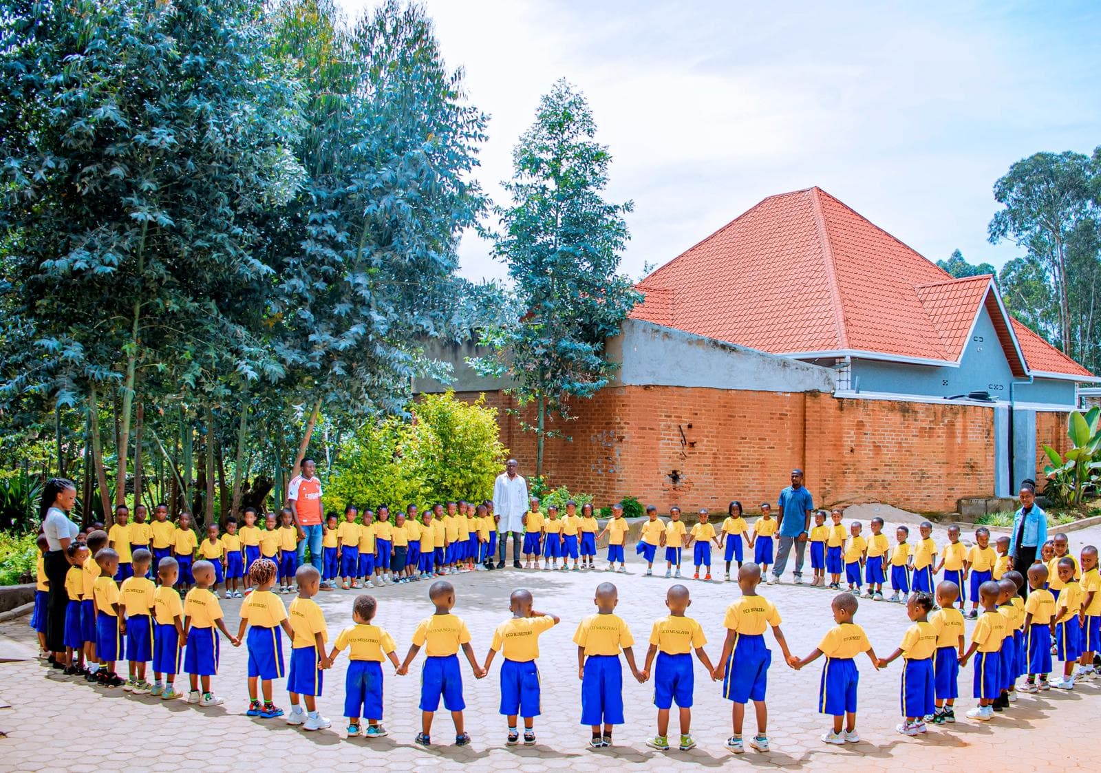 Children of ECD Musezero forming a circle in the schoolyard